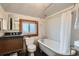Well-lit bathroom with clawfoot tub, vintage fixtures and a dark vanity cabinet at 209 S Lincoln St, Denver, CO 80209