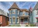 Charming two-story blue home with a turret and a cozy front porch perfect for relaxing at 209 S Lincoln St, Denver, CO 80209