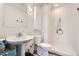 Bathroom with white tiled shower and walls, features a pedestal sink at 1300 S Monaco Pkwy # 12, Denver, CO 80224