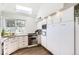 Well-lit kitchen with granite counters, stainless appliances, and bright white cabinetry at 1300 S Monaco Pkwy # 12, Denver, CO 80224