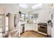 Eat-in kitchen with stainless steel appliances, white cabinets, granite countertops, and natural light at 1300 S Monaco Pkwy # 12, Denver, CO 80224