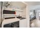 Chic laundry room with modern washer and dryer, stylish circle pattern wallpaper, and open shelving at 1300 S Monaco Pkwy # 12, Denver, CO 80224