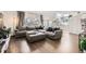 Living room with hardwood floors, sectional couch, and large windows with natural light at 1300 S Monaco Pkwy # 12, Denver, CO 80224