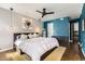 Main bedroom with ceiling fan, art, ensuite bathroom, and sleek, dark wood furnishings at 1300 S Monaco Pkwy # 12, Denver, CO 80224