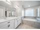Elegant bathroom with dual sinks, soaking tub, and modern fixtures for a luxurious experience at 18189 House Finch Ln, Parker, CO 80134