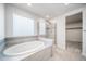 Spa-like bathroom with soaking tub, glass-enclosed shower, and modern fixtures at 18189 House Finch Ln, Parker, CO 80134
