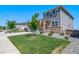 Charming two-story home boasts a manicured lawn, stone accents, and an inviting front porch at 18189 House Finch Ln, Parker, CO 80134