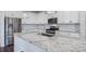 Bright kitchen features stainless steel appliances, white cabinets, and a large granite island with a sink at 18189 House Finch Ln, Parker, CO 80134