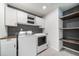 Well-lit laundry room features white cabinets, butcher block counters, floating shelves, and gray backsplash at 18189 House Finch Ln, Parker, CO 80134