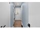 Narrow hallway with stacked laundry and entry doors at 1246 S Routt Way, Lakewood, CO 80232