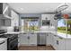 Bright kitchen features stainless appliances, white cabinetry and quartz countertops at 1246 S Routt Way, Lakewood, CO 80232
