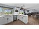 Updated kitchen with new white cabinetry, stainless appliances and views into the living room at 1246 S Routt Way, Lakewood, CO 80232