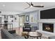 Bright living room featuring a cozy fireplace, hardwood floors, and a view into the kitchen at 1246 S Routt Way, Lakewood, CO 80232