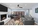 Bright living room featuring a cozy fireplace, hardwood floors, and custom built-in bookshelves at 1246 S Routt Way, Lakewood, CO 80232