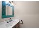 Stylish powder room featuring a mosaic-framed mirror and modern black fixtures at 1246 S Routt Way, Lakewood, CO 80232