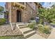 Arched entrance to a stone and stucco townhome with concrete steps and walkway at 3491 Cascina Pl # D, Highlands Ranch, CO 80126
