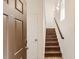 Welcoming entryway with wood stairs and a white door leading into the home at 3491 Cascina Pl # D, Highlands Ranch, CO 80126