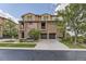 Charming multi-story townhouse featuring stone and stucco facade, attached two-car garage and lush landscaping at 3491 Cascina Pl # D, Highlands Ranch, CO 80126