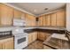 Well-lit kitchen with oak cabinetry, tile countertops, a white stove, oven and sink at 3491 Cascina Pl # D, Highlands Ranch, CO 80126
