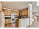 Kitchen offers wooden cabinets, white appliances, and a breakfast bar that opens up to the dining area at 3491 Cascina Pl # D, Highlands Ranch, CO 80126