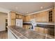 This kitchen features oak cabinets, tile countertops, tile flooring, and a breakfast bar area at 3491 Cascina Pl # D, Highlands Ranch, CO 80126