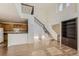 Open-concept living space with hardwood floors, bar seating, and staircase with rod iron at 3491 Cascina Pl # D, Highlands Ranch, CO 80126