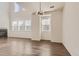 Bright living room features wood floors, fireplace, and an elegant chandelier under soaring ceilings and multiple windows at 3491 Cascina Pl # D, Highlands Ranch, CO 80126