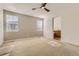 Spacious primary bedroom with plush carpeting, ceiling fan and an attached bathroom at 3491 Cascina Pl # D, Highlands Ranch, CO 80126