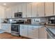 Well-lit kitchen features stainless steel appliances, gray countertops, white cabinets, and stylish backsplash at 13563 E 106Th Pl, Commerce City, CO 80022