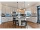 Modern kitchen with an island, stainless steel appliances, white cabinets, and pendant lighting at 13563 E 106Th Pl, Commerce City, CO 80022