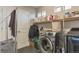 Functional laundry room with modern washer and dryer, storage shelf and small window at 13563 E 106Th Pl, Commerce City, CO 80022