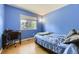 Bright blue bedroom featuring natural light, hardwood floors, and space for a bed and a desk at 2269 S Yank Ct, Lakewood, CO 80228