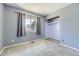 Blue bedroom featuring newer carpet, a window, and an open closet for easy storage solutions at 2269 S Yank Ct, Lakewood, CO 80228