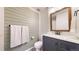 Updated bathroom featuring modern vanity, stylish mirror, shiplap accent wall and decorative fixtures at 10718 Ash Ct, Thornton, CO 80233