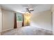 Bright bedroom with large window, ceiling fan, carpeted floors, and neutral color scheme at 10718 Ash Ct, Thornton, CO 80233
