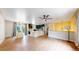 Open-concept living room with natural light, ceiling fan, hardwood floors, and stairs to upper level at 10718 Ash Ct, Thornton, CO 80233