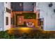 Aerial view of a rooftop patio with dining and lounge areas, set amidst lush landscaping and ambient string lights at 3220 Zuni St, Denver, CO 80211