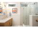 Bright bathroom featuring dual sinks, modern lighting fixtures, and a glass-enclosed shower with sleek gold hardware at 3220 Zuni St, Denver, CO 80211