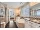 Bright bathroom features a soaking tub, double sinks with granite counters, and tiled floors at 9724 Cantabria Pt, Lone Tree, CO 80124