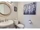 Elegant powder room featuring a stylish vanity with a round mirror and modern fixtures at 9724 Cantabria Pt, Lone Tree, CO 80124