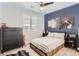 Stylized bedroom with dark wood accents, modern light fixture, and stylish decor at 9724 Cantabria Pt, Lone Tree, CO 80124