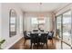 Bright dining room with large windows, elegant chairs, and sleek hardwood floors, ideal for entertaining guests at 9724 Cantabria Pt, Lone Tree, CO 80124