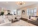 Open living room showcasing a sectional sofa and a view into the kitchen at 9724 Cantabria Pt, Lone Tree, CO 80124