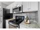 Kitchen featuring a black oven, stainless steel microwave, and white cabinets at 3137 S Glencoe St, Denver, CO 80222