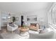 Bright living room featuring a tufted sofa, plush armchairs, and light wood floors at 3137 S Glencoe St, Denver, CO 80222