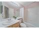 Well-lit bathroom featuring a shower-tub combination and a large mirror above the sink at 12229 W Berry Ave, Littleton, CO 80127