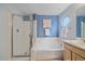 Bathroom featuring a bathtub, separate glass-enclosed shower, and single vanity at 12229 W Berry Ave, Littleton, CO 80127