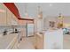 Bright eat-in kitchen with tile floor, modern appliances, and breakfast bar at 12229 W Berry Ave, Littleton, CO 80127