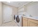 Functional laundry room with modern washer and dryer, sink, and ample storage space at 12229 W Berry Ave, Littleton, CO 80127