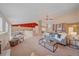 Open-concept living room with a neutral color palette, cozy seating, and plenty of natural light at 12229 W Berry Ave, Littleton, CO 80127